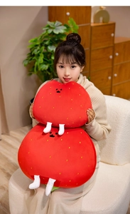 Asian model holding a long strawberry plush pillow with cute facial features