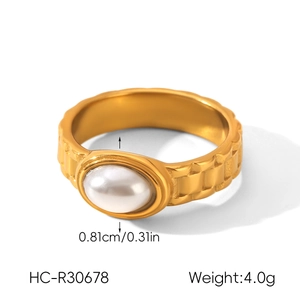 Vue macro de la bague en acier inoxydable doré avec perle et textures gravées
