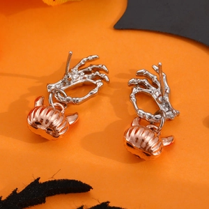 Punk Halloween pumpkin and skull hand drop earrings on vibrant orange bat background