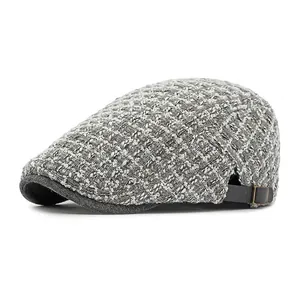 Vintage geruite grijze tweed pet met leren zijriempje en een metalen gesp als detail