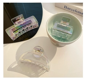 Detail view of colorful iridescent acrylic shark hair clips in various geometric shapes