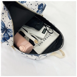 Internal view of a white backpack with blue butterfly prints showing spacious storage