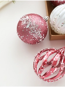 Detailed close-up of 8cm glitter and sequin Christmas ornaments in pink, red and white