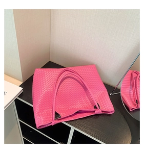 Detail of woven leather texture on fuchsia pink tote bag with elegant thin dual handles