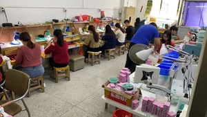 Professional jewelry manufacturing and assembly workshop showing workers at work desks