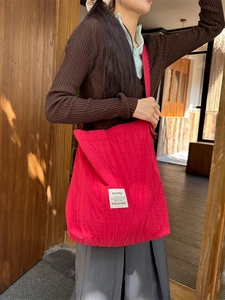 Red quilted canvas tote bag with vertical stripes shown on model for daily commuting use