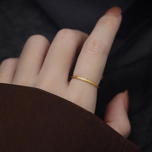Minimalist 18K gold plated titanium ring with three tiny diamonds on a thin wire band