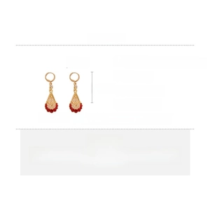 Detailed specs of teardrop earrings with gold mesh and red rhinestone accents