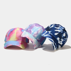 Three colorful tie-dye baseball caps in pink, yellow, and blue cotton canvas with curved brim