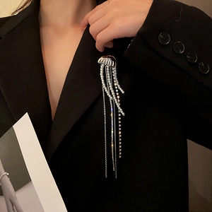 Elegant silver jellyfish brooch with tassels, pearls and rhinestones on a black suit