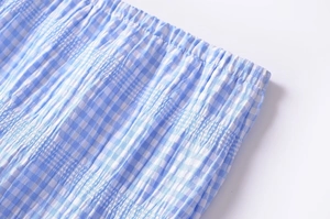 Detail of blue and white plaid fabric with elastic shirred waistband craftsmanship