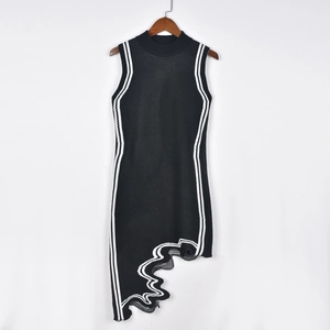 Detalle de vestido negro de punto sin mangas con rayas blancas onduladas en percha de madera