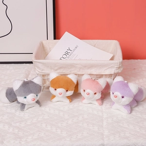 Macro detail of four cute plush husky fox doll charms in grey, orange, pink and purple