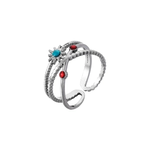 Detail of multi-layered stainless steel ring with starburst blue and red gems