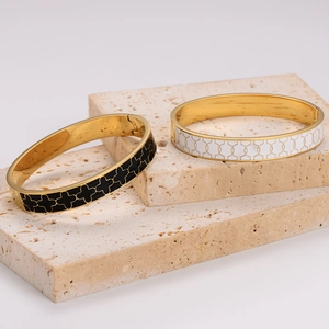 304 stainless steel enamel buckle bracelets in black and gold on travertine stone