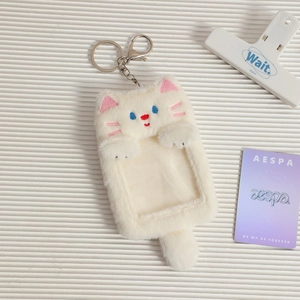Detail of white plush cat photocard holder with transparent window and silver keychain