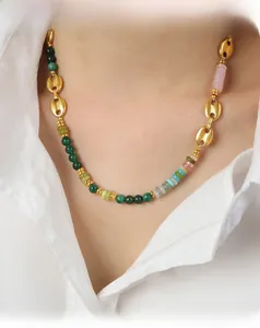 Gros plan d'un collier de perles vintage en agate colorée avec un maillon nez de cochon