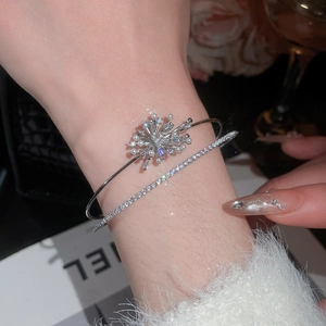 Macro detail of silver double-layered open cuff with zircon snowflake and pearl accents