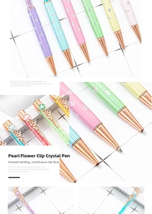 Detail of metal hollow flower and pearl clip on pastel crystal ballpoint pens