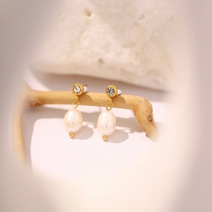 Primer plano detallado de pendientes de perlas de agua dulce de oro 18k con circonitas