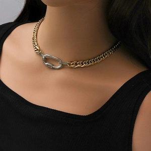 Close-up of dual-tone chunky Cuban chain necklace with silver carabiner clasp on model