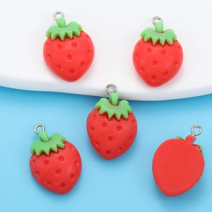 Detailed macro shot of DIY resin strawberry pendants with metal hanging loops and flat back