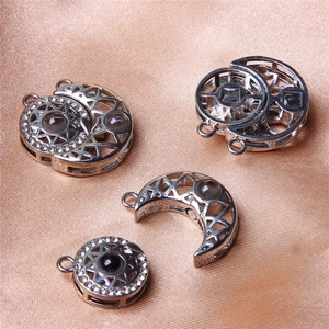 Detail of sun and moon magnetic pendants on champagne satin with hollow star pattern