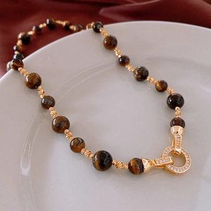 Detailed view of tiger eye beads and gold-plated cubic zirconia clasp on a vintage necklace