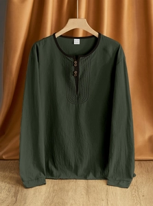 Close-up of dark green linen Henley shirt on wooden hanger with textured fabric detail