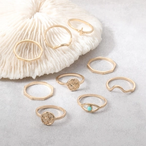 9-piece gold fashion ring set featuring wave patterns and turquoise stone on coral