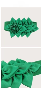 Detailed tile display of green elastic waist belt with ornate fabric flower decoration