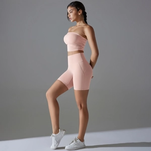 Side view of pink pleated sports set featuring high-waisted shorts and cropped tube top