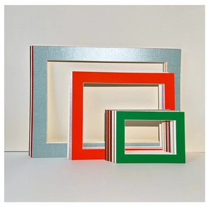 Close-up of stacked colorful mat boards for DIY art frames in various sizes and textures