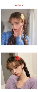 Detail showing yellow and red heart-shaped plush hair clips worn as side accessories