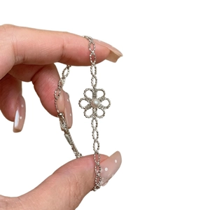 Bracelet argenté élégant avec breloque fleur évidée et perle blanche pour femme