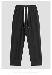 Detail of black loose casual pants with elastic drawstring waist and vertical seam stitching
