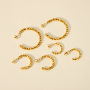 Three sizes of 18K gold plated twisted rope C-shaped hoop earrings set on beige background