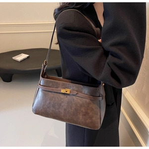 Dettaglio di una borsa a tracolla in pelle vintage marrone con chiusura a scatto oro