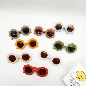 Collection of flower-shaped kids sunglasses in eight soft matte colors on white background