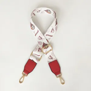 Detail of colorful hot air balloon print bag strap with red leather ends and gold hooks