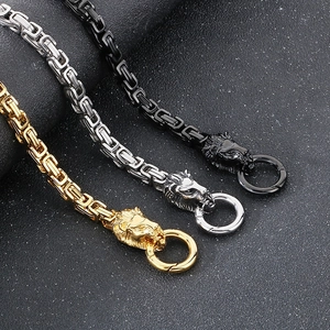 Detail of lion head clasps on gold, silver, and black metal woven king chains