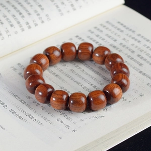 Macro detail of Dalbergia retusa wooden beads with natural grain on vintage paper