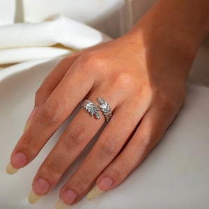 Detailed view of a silver leaf-shaped open ring made of polished stainless steel