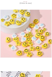 Close-up of yellow and white ceramic smiley face beads in heart, star and cloud shapes
