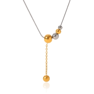 Macro detail of bicolor steel necklace featuring gold and silver bead fringe pendant