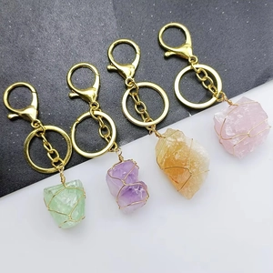 Vue détaillée de quatre porte-clés en cristal brut enveloppés de fils dorés tressés
