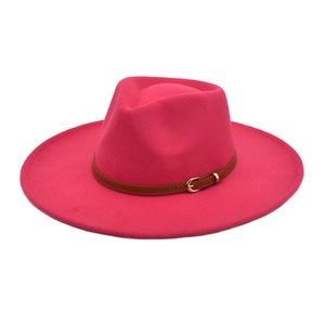 Dettaglio del cappello fedora rosso rosa con cintura in pelle marrone e fibbia d'oro