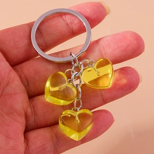 Detailed close-up of a silver keychain with three translucent yellow resin heart charms