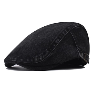 Détail du béret en denim noir délavé avec boucle latérale réglable en bronze vintage