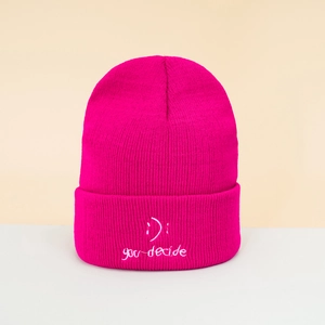 Close-up of rose red beanie with white 'you decide' embroidery and smile symbols